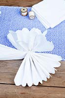 Making a paper pom pom from napkins. Separate the layers of paper fan and start to pull them upwards to form a pompom ball.