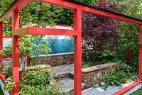 Hagakure - Hidden Leaves - Japanese modern,  terraced garden in red framing with luxuriant shade planting including Acer 'Fireglow', hostas, ferns , hydrangea and Heuchera sanguinea 'Alba' - RHS Chelsea Flower Show 2017 