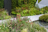 Stream running beneath  stone path with mixed planting - The Jeremy Vine Texture Garden - Radio 2 Feel Good Gardens -RHS Chelsea Flower Show 2017 - Designer: Matt Keightley