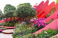 Coloured fins with insect houses, interplanted with Viburnum davidii, Rhododendron and herbaceous perennials - The Chengdu Silk Road Garden - RHS Chelsea flower show 2017 - Designer: Laurie Chetwood and Patrick Collins