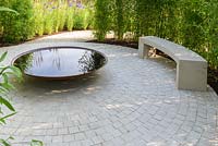 Seating area with stone bench and corten steel water bowl -The Perennial Sanctuary Garden - RHS Hampton Court Palace Flower Show 2017 - Designer: Tom Massey