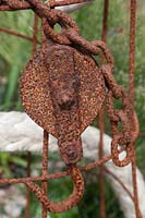 Rusted metal chain and pulley sculpture
