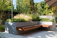 Contemporary seat and raised bed with  Salvia officinalis 'Kew Gold', Stipa tenuissima, Pennisetum thunbergii 'Red Buttons', Thymus 'Silver Queen'.