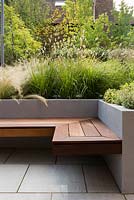 Contemporary seat and raised bed with Stipa tenuissima, Pennisetum thunbergii 'Red Buttons', Salvia officinalis 'Kew Gold', Thymus 'Silver Queen', Molinia caerulea 'Karl Foerster'