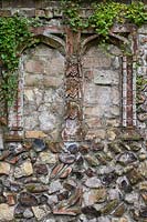 Part of 'Medieval' wall incorporating pseudo-ecclesiastical 'alcoves' and ornamental bricks and  flints. Trailing plant is Cymbalaria muralis - Kenilworth Ivy.