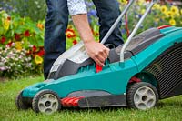 Raising the height of blades on a rechargeable electric lawnmower, July