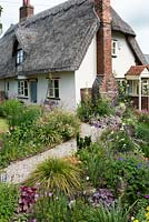 Caynton Cottage, a seventeenth century thatched cottage, is reached via gravel paths edged in perennials.