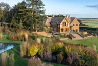 Prairie style beds, with modern Arts and Crafts style house set against a backdrop of the Welland Valley.