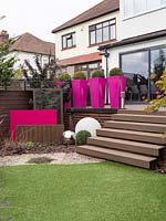Tall pink planters provide instant impact and stature to the garden.  They also provide height being positioned on the upper deck.
