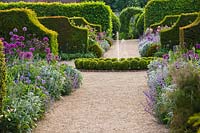 Path to fountain with Box balls, Alliums and Yew hedges, The Collector Earls garden, Arundel Castle, West Sussex, May
