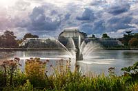 Fountain, lake and victorian palm house in Autumn - Royal Botanic Gardens, Kew