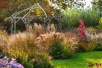 Coppiced ash and hazel gazebo with Stipa calamAgrostis 