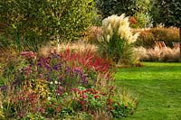 Informal beds with Cortaderia selloana - pampas grass and Persicaria 'Atrosanguinea', Monarda 'Cambridge Scarlet', Aster novae-angliae 'Violatta'