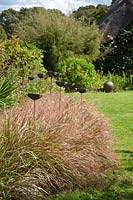 Pottery finials amongst plants in the Garden Pottery of Jonathan Garratt in Dorset