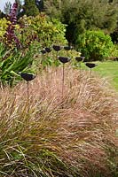 Pottery finials amongst plants in the Garden Pottery of Jonathan Garratt in Dorset