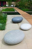 Large sculptural stone pebbles in a contemporary garden, designed by Robert Myers at the RHS Chelsea Flower Show 2013.