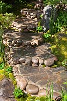 Stone and pebble path with shallow steps in a Japanese style garden