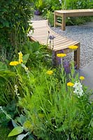 Contemporary garden with gravel path and curved wooden benches. Designers Catherine Chenery Barbara Harfleet