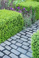 Support, The Husqvarna Garden. RHS Chelsea Flower Show 2016. Designer: Charlie Albone. Bluestone cobble path, clipped Buxus.