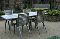 Contemporary garden furniture of table chairs on brick paved patio