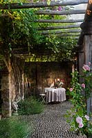 Table and chairs set for a meal in a quiet alcove at Borgo Santo Pietro, Tuscany, Italy