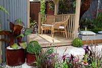 Wooden patio with container plants, garden furniture, garden bench