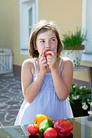 Girl eating tomato