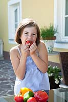 Girl eating a tomato