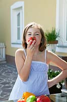 Girl eating a tomato