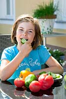 Girl eating a cucumber