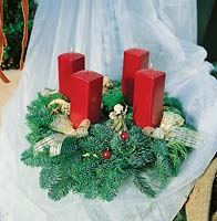 Adventskranz mit roten eckigen Kerzen und goldenem Dekor