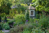 Bullock Horn Cottage, Wilts, UK ( des. Liz Legge ) small, contemporary cottage garden in early summer, summerhouse and pergola