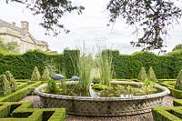 Bourton House Garden, Gloucestershire. Mid summer. The formal knot garden with 'Basket' pond