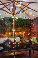 Evening beneath parasol with candles, in small patio courtyard area