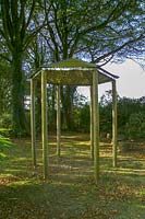 Pinsla Garden, Cornwall, UK. Late summer garden , rustic wooden summerhouse/shelter in woodland garden with mirrored ceiling inside