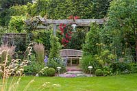 18 Queens Gate, Bristol, UK ( Sheila White ) small town garden in summer. pergola in corner with restful bench seat