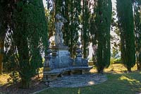 Villa La Foce, Tuscany, Italy. Large garden with topiary clipped Box hedging and views across the Tuscan countryside, statue in lower terrace garden