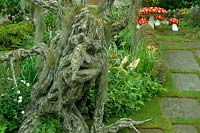 Hampton Court FS 1992 Children s fantasy garden with knarled tree troll with face Fairy mushroom seats and table