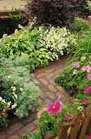 zig zag meandering brick path with flower borders either side