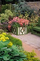 Chelsea FS 1991 Design Peter Rogers pink pelargoniums in Versailles tub beside bench on patio