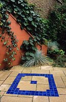 private town garden London Design Pamela Woods Mediterranean patio garden with blue ceramic tiles and orange colour washed wall