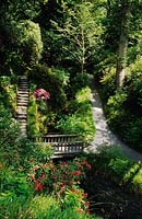 Bodnant North Wales path and steps leading down sloping garden to bridge over stream and water cascades