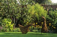 garden sculptural geese woven from willow hazel sticks on lawn