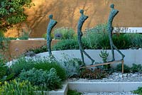 Sculpture of three human figures, designed by Michael Speller, in The Dubai Majlis Garden. Designed by Thomas Hoblyn. Sponsored by Dubai. RHS Chelsea Flower Show, 2019.
