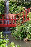 The Trailfinders 'Undiscovered Latin America' Garden, view of the red bridge and one of the waterfalls - Designer: Jonathan Snow - Sponsor: Trailfinders. RHS Chelsea Flower Show 2019