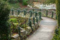 A view of a path with swags of Hedera, Ivy at Brodsworth Hall, Yorkshire.  