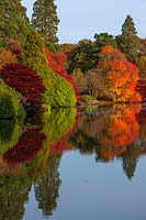 Autumnal trees reflected in lake, National Trust - Sheffield Park and Garden, East Sussex.