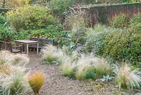Sunken gravel garden with self seeded grasses, Cambridge