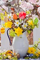 Easter display of Daffodils, Hazel, Tulips and Acer branches in jug