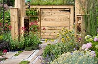 Bin storage made with recycled wood with green roof and pockets planted with wild strawberries Fragaria vesca and herbs - BBC Gardener's World Live, Birmingham 2017 - Artemis Landscapes Living in Sync Garden